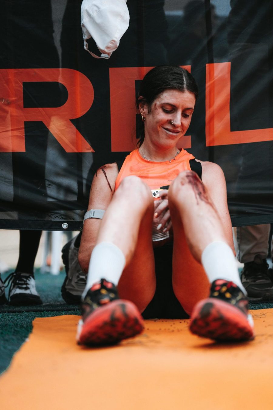 woman sits by a wall exhausted from running competition